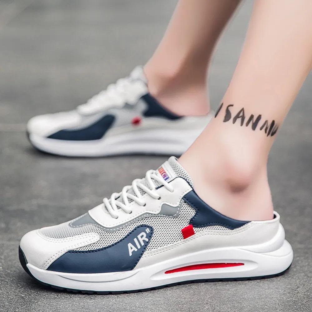 White and blue sneakers with red accents worn by a person on a gray pavement.