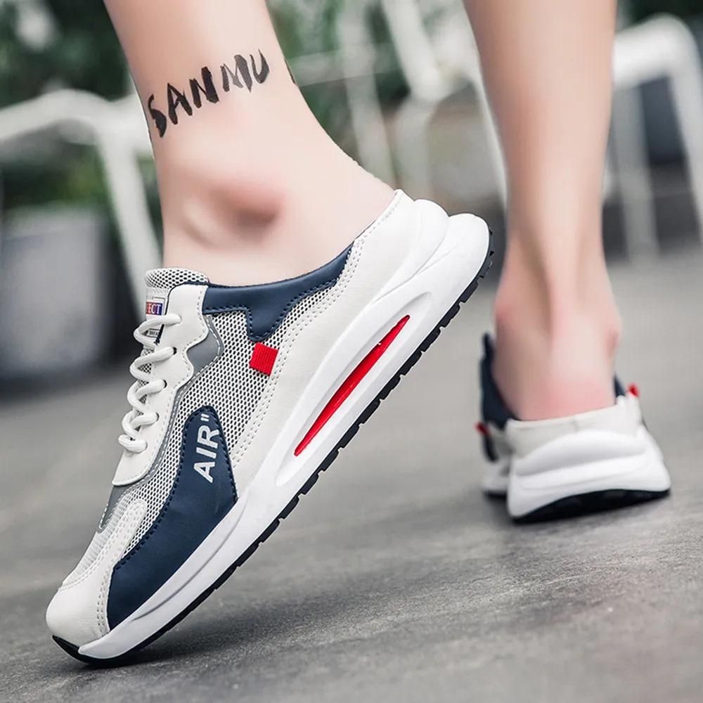 White, gray, and red sneakers worn by a person with 'SANMU' tattoo on foot.