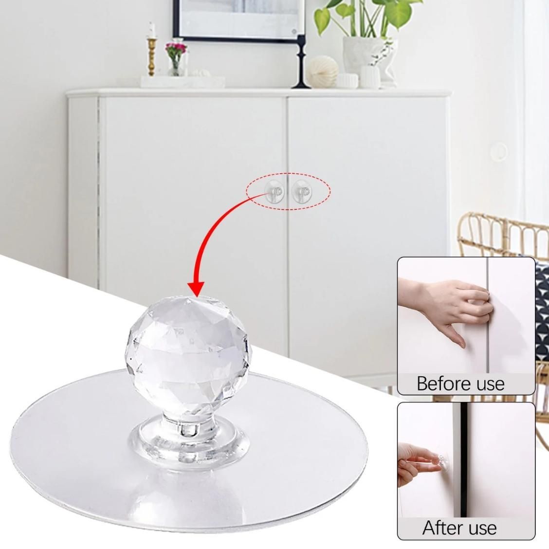 Clear glass ball with adhesive pads on a white surface, with a cabinet and decorative items in the background.
